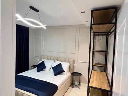 a bedroom with a bed with blue pillows at The Harmony Duo in Tirana