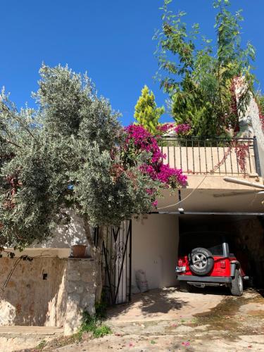 Een rode auto staat geparkeerd in een garage. bij Villa Valo in Kalkan