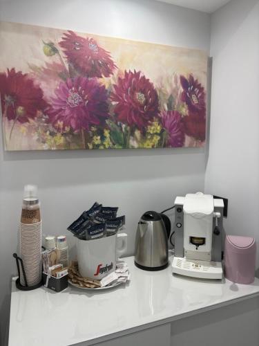 a kitchen counter with a flower painting on the wall at Affittacamere ONE in Frascineto