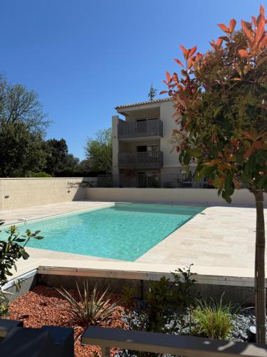 une piscine devant une maison dans l'établissement Appartement neuf piscine de standing Uzes à pied, à Uzès