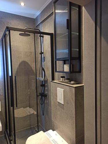 a shower with a glass door in a bathroom at Sodi Cozy apartment in Kardítsa