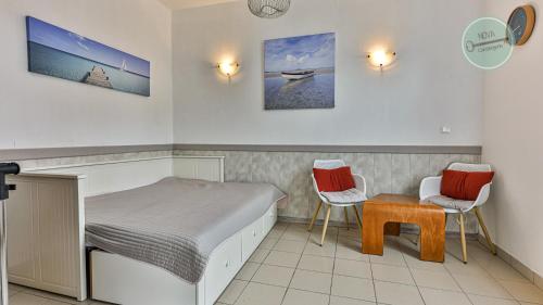 une chambre avec un lit, deux chaises et une table dans l'établissement Studio mezzanine Seringas, à Plage-des-Demoiselles
