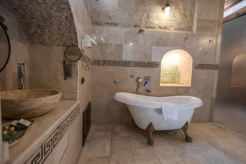 a bathroom with a tub and a sink at Göreme Cave Suites in Goreme