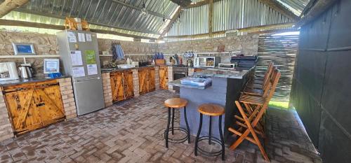 a large kitchen with a counter and stools in it at Tamboti Farm Self-Catering Accommodation in Tsumeb