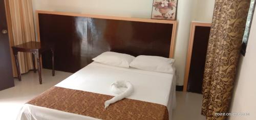 a bed with a white snake sitting on top of it at Twin Hearts Resort Pool Cabin 2 in Jasaan