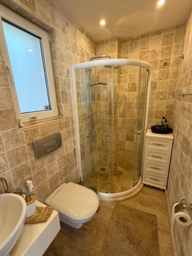 een badkamer met een douche, een toilet en een wastafel bij Villa Valo in Kalkan