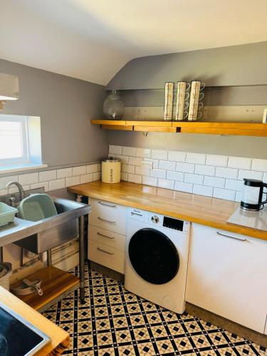 a kitchen with a washing machine and a sink at The Hope in Trowbridge