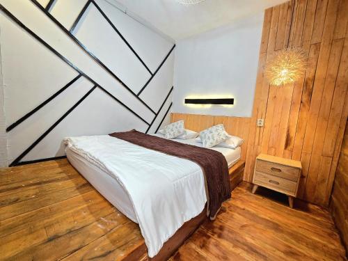 a bedroom with a bed and a wooden floor at Cabin Linggayoni dieng in Dieng