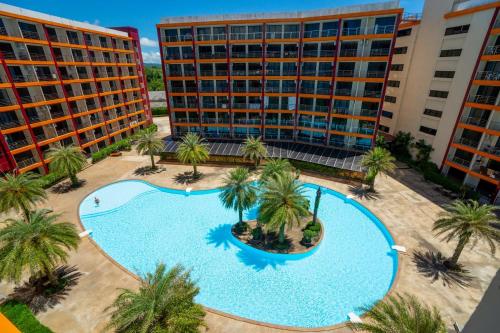 an overhead view of a swimming pool with palm trees and buildings at The Urban Tropical Apartments in Mai Khao Beach