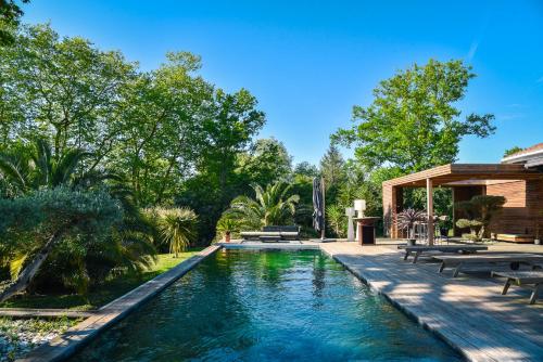 - une piscine dans une cour avec bancs et arbres dans l'établissement La Cierba Villa avec piscine et jacuzzi, à Angresse