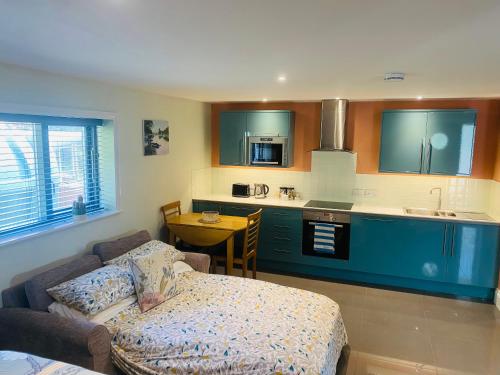 a living room with a couch and a kitchen at The Apartment at Estuary Escapes in Kingsbridge