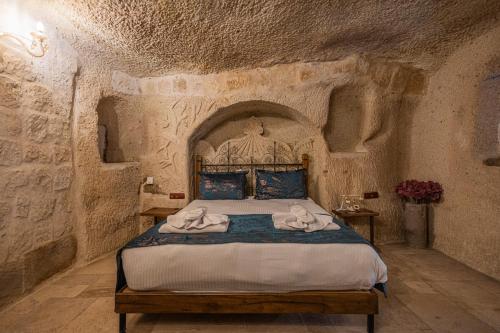 a bedroom with a bed in a stone room at Göreme Cave Suites in Goreme