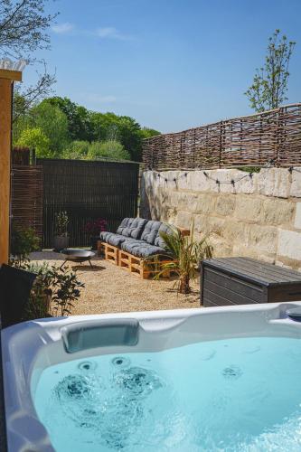 un bain à remous dans une cour avec patio dans l'établissement La Maison D'Ambre - Jacuzzi - Sauna- Clim, à Saumur