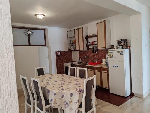 a kitchen with a table and a white refrigerator at Petrovic house in Herceg-Novi