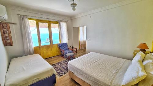 a bedroom with a bed and a window and a chair at Uğrak Home in Işıklı