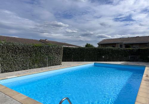 une piscine bleue en face d'une clôture dans l'établissement Lumaïa - Vue cité, terrasse & Piscine, à Carcassonne