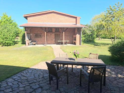 a table and chairs in a yard with a house at Farm-Chalets Apartment Park in Renzow