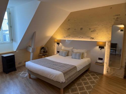 une chambre avec un grand lit dans une pièce dans l'établissement Hotel Restaurant Lesage, à Sarzeau