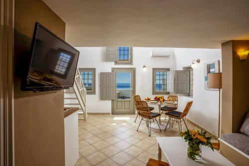 a kitchen and living room with a table and chairs at Mardanza House in Imerovigli