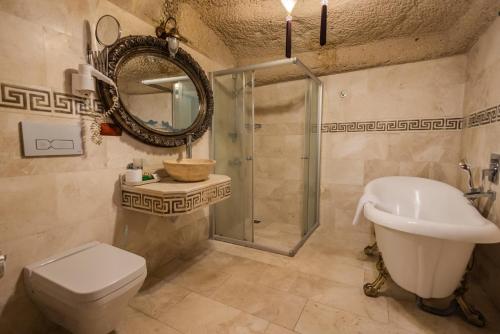 a bathroom with a toilet and a sink and a shower at Göreme Cave Suites in Goreme