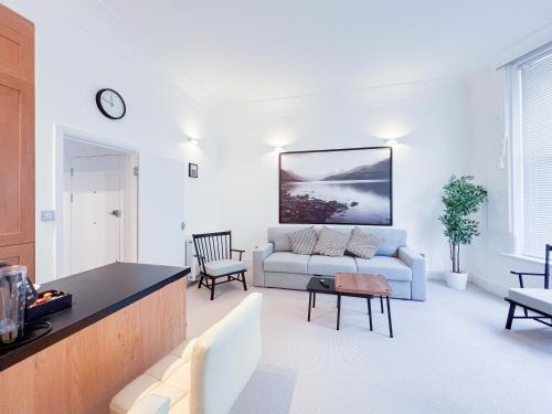 ein Wohnzimmer mit Sofa und Tisch in der Unterkunft The Fitz Central Apartment in London