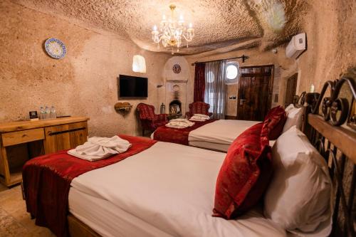 a hotel room with two beds and a chandelier at Göreme Cave Suites in Goreme