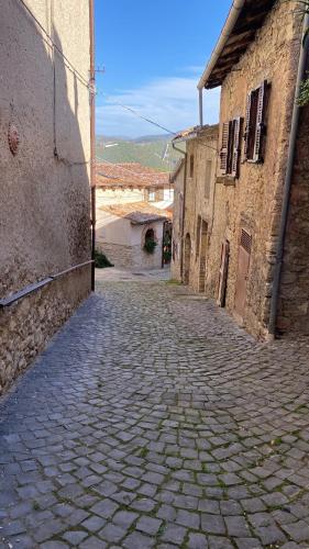 an alley with a cobblestone street between two buildings at La casa nel borgo in Monte Sabinese