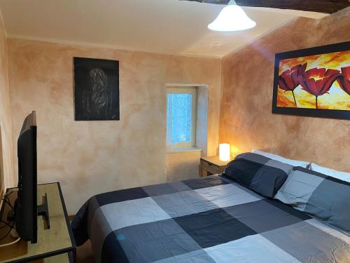 a bedroom with a bed and a flat screen tv at La casa nel borgo in Monte Sabinese