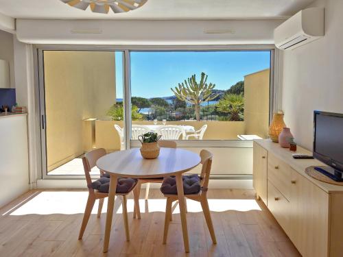 une cuisine avec une table et des chaises ainsi qu'une grande fenêtre dans l'établissement Les Ondines sea view with air conditioning, à Bormes-les-Mimosas