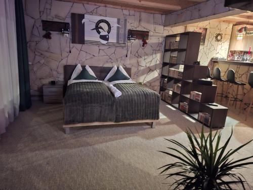 a bedroom with a bed and a stone wall at Edelweiss Cozy Lodge in Braşov