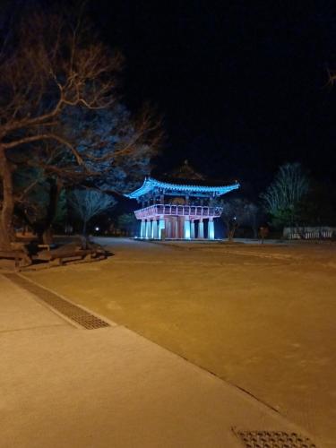 a building with blue lights in a park at night at Naganeupseong Jandi House in Suncheon