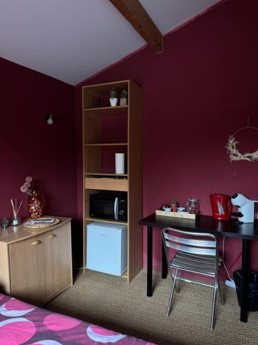 Cette chambre violette comprend une table et une chaise. dans l'établissement La petite maison chez jp Eurexpo-LDLC arena-Stade OL, à Chassieu