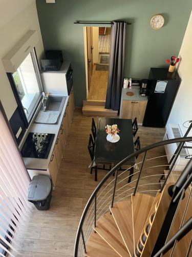 une chambre avec un escalier, une table et une cuisine dans l'établissement La datcha, à Drouvin-les-Marais