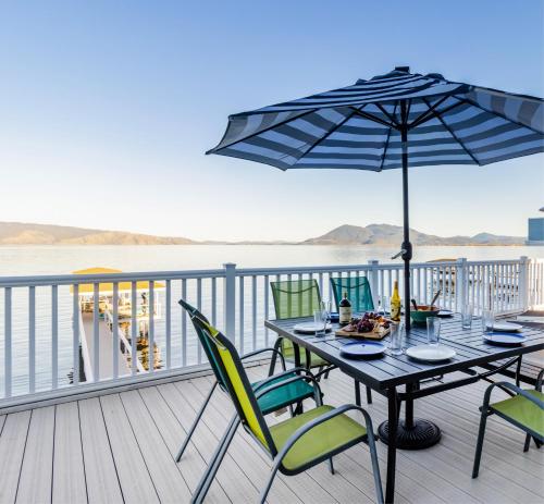 - une table avec des chaises et un parasol sur une terrasse dans l'établissement Waterfront Home - Private dock Pickleball BBQ home, à Lakeport