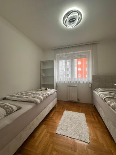 a bedroom with two beds and a window at Istocno Sarajevo-Hilandarska, Stan na dan SV in Donje Mladice
