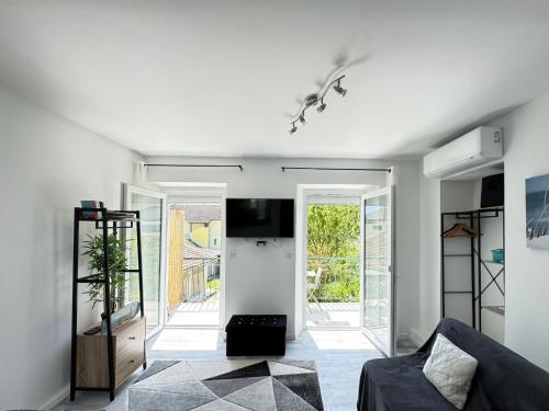 un salon avec un canapé et une télévision dans l'établissement Charmant T1 entre ville et lac avec balcon, à Aix-les-Bains