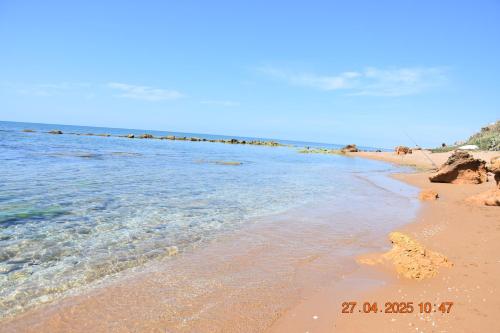 a beach with the ocean and the shoreline at Casa Vacanze Giorgia in Marinella di Selinunte