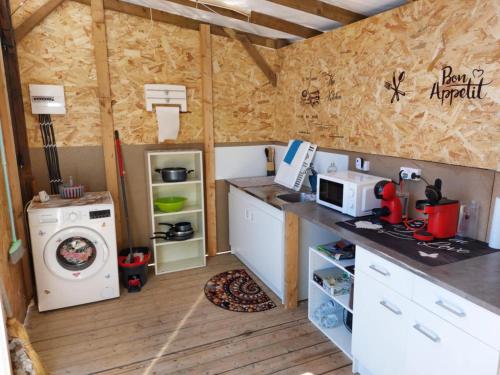 une petite cuisine avec une cuisinière et un micro-ondes dans l'établissement CHALET SUR TERRAIN PRIVER, à Vias