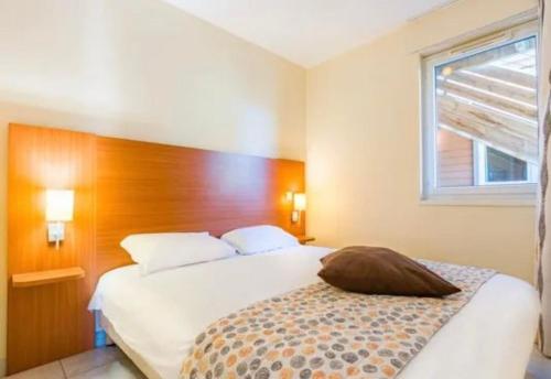 ein Schlafzimmer mit einem weißen Bett mit einem hölzernen Kopfteil in der Unterkunft Cottage chateau de la loire in Chaveignes