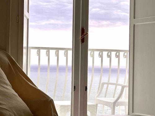 a bedroom with a door open to a balcony with a chair at Filippescha in Positano