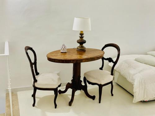 a table and two chairs with a lamp and a bed at Filippescha in Positano