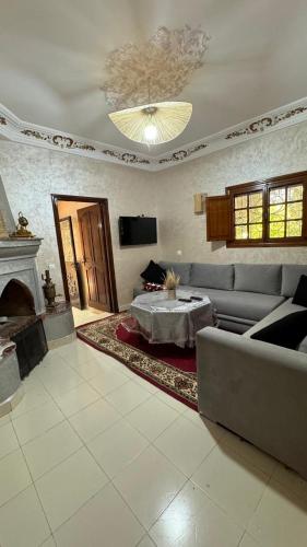 a living room with a couch and a fireplace at Eco Farm Tayssir Marrakech in Marrakech