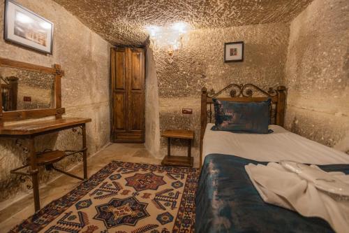 a bedroom with a bed and a desk in a room at Göreme Cave Suites in Goreme