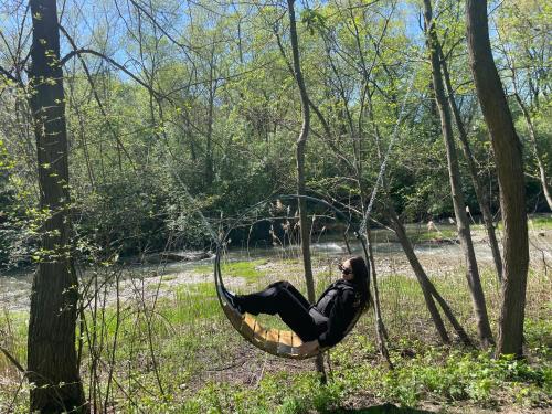 a woman sitting in a swing in the woods at Stary Mlyn in Yabluniv
