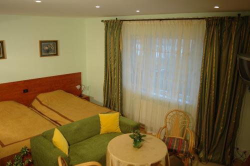 a bedroom with a green couch and a bed at Country Club La Mesteceni in Sebeş