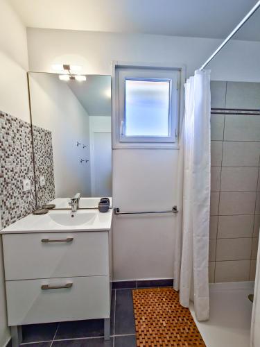 une salle de bain avec un lavabo et une douche avec une fenêtre dans l'établissement Rooftop du Lavandou - terrace and pool, au Lavandou