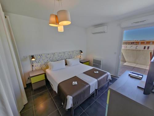 une chambre d'hôtel avec un lit et un balcon dans l'établissement Rooftop du Lavandou - terrace and pool, au Lavandou