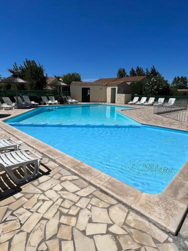 une grande piscine bleue avec des chaises longues dans l'établissement maison 4 personnes avec piscine, mer 200m à pieds, à Marseillan