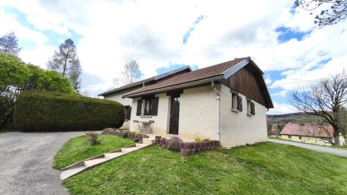 a small white house with a grass yard at Un séjour à Foncine in Foncine-le-Haut