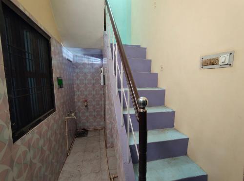 a stairway with blue steps and a glass railing at Sneh Homestay in Ayodhya